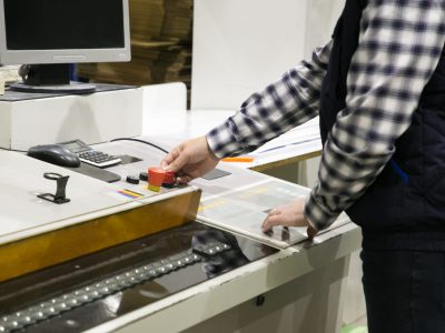 Cropped shot of milling machine operator at his workplace. Middle aged man working at plant. Automation and machinery concept